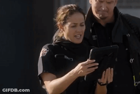 Policewoman Looking At Tablet With Man Behind GIF