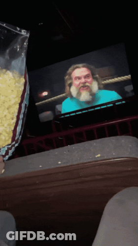 Popcorn Bag Poured In Front Of Bearded Man GIF
