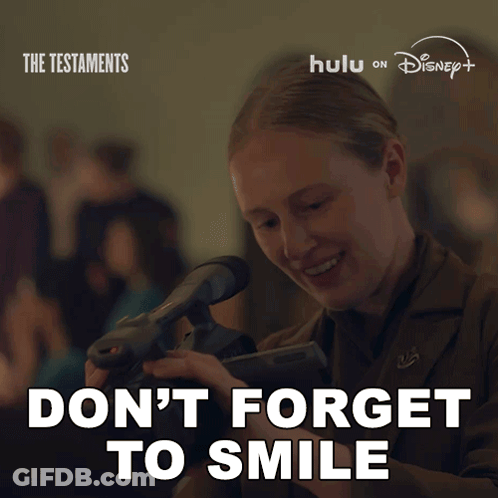 Poster Woman Holding Camera Says Don't Forget To Smile GIF