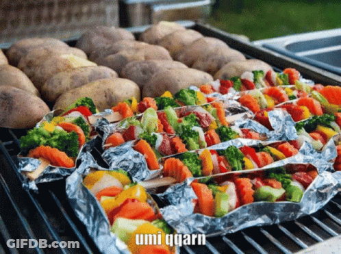 Potatoes And Vegetables Wrapped In Aluminum Foil On A Grill With Umi Qqarn In The Corner GIF