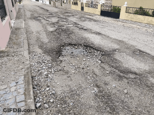 Pothole In Road With Fence Background GIF