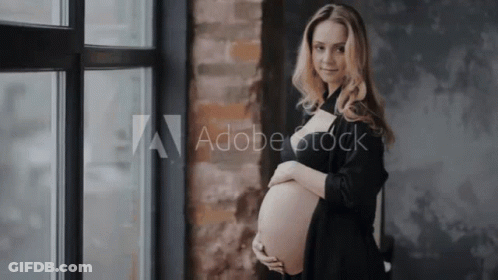 Pregnant Woman In Black Dress Holding Belly GIF