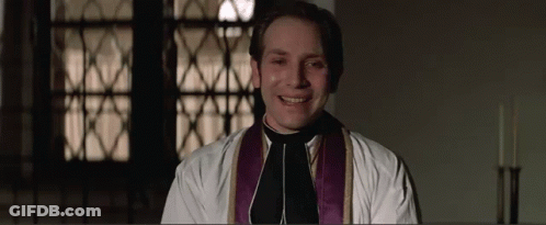 Priest In White Robe And Purple Vest Smiling GIF