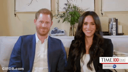 Prince Harry And Meghan Markle Sitting On Couch Smiling GIF