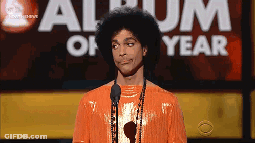 Prince Is Standing In Front Of A Microphone At An Album Of The Year Awards GIF