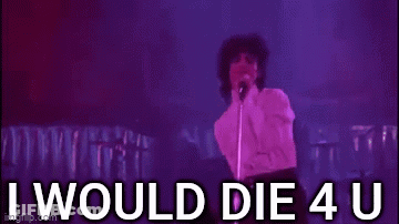 Prince Is Standing In Front Of A Microphone On A Stage And Singing . GIF