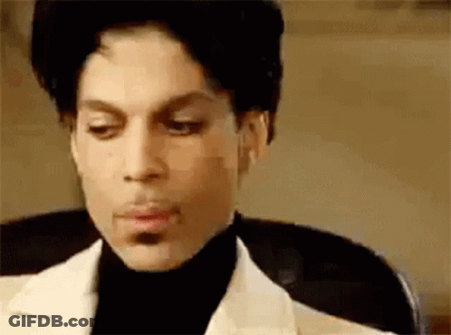 Prince Is Wearing A White Suit And Black Turtleneck . GIF