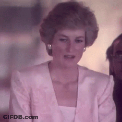 Princess Diana Is Wearing A Pink Jacket And White Top While Sitting In Front Of A Man . GIF