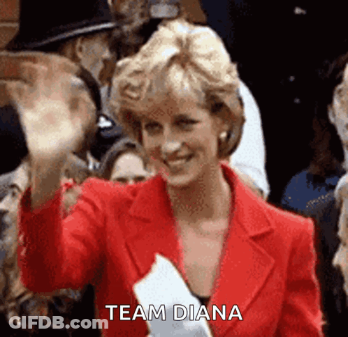 Princess Diana Is Wearing A Red Jacket And Waving At The Camera While Holding A Piece Of Paper That Says Team Diana . GIF