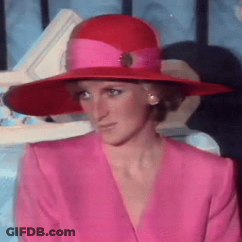 Princess Diana Wearing A Pink Suit And A Red Hat . GIF