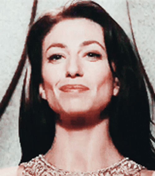 Proud Claudia Black Demure Smile GIF