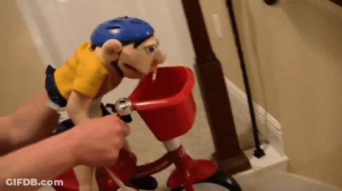 Puppet In Blue Helmet Riding Red Bicycle With Basket GIF