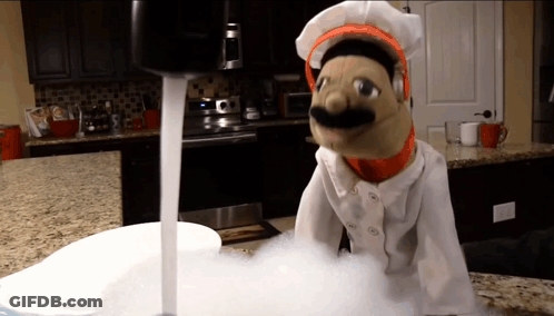 Puppet In Chef Uniform Standing Next To Sink GIF