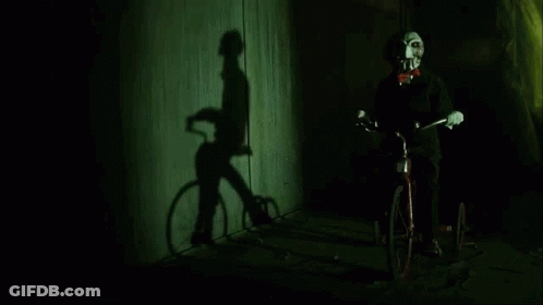 Puppet Riding Bicycle With Shadow On Wall GIF
