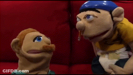 Puppet Sitting On Red Couch With Blue Hat GIF