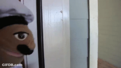 Puppet Wearing Chef Hat Looking Out Door GIF