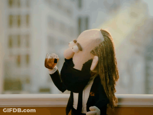Puppet With Dreadlocks And Beard Drinking From Glass GIF