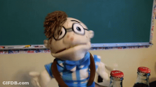 Puppet With Glasses And Bow Tie In Front Of Chalkboard GIF