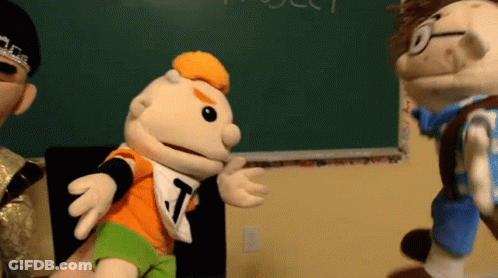 Puppet With Letter T Talking To Another Puppet GIF