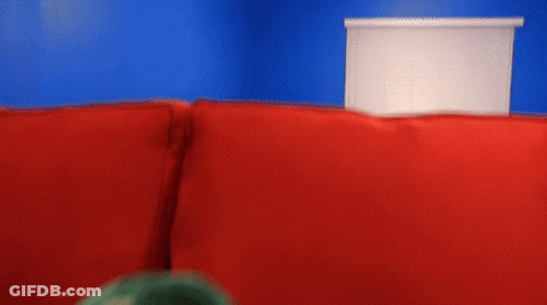 Puppet With Open Mouth On Red Couch GIF