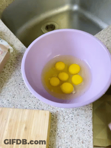 Purple Bowl Filled With Yellow Eggs Beside Sink GIF