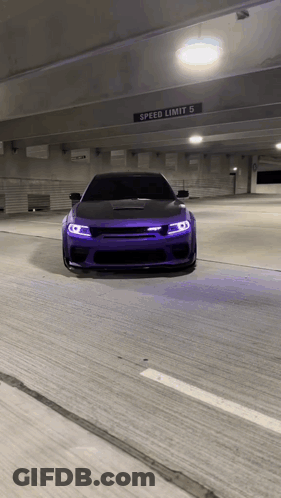 Purple Car Driving Under Speed Limit Sign In Parking Garage GIF