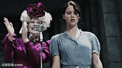 Purple Jacket Woman And Blue Shirt Woman Holding Microphone GIF