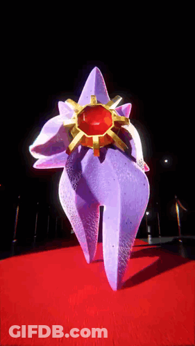 Purple Sculpture With Gold Ring On Red Carpet GIF