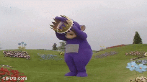 Purple Teddy Bear With Crown In Field Of Flowers GIF