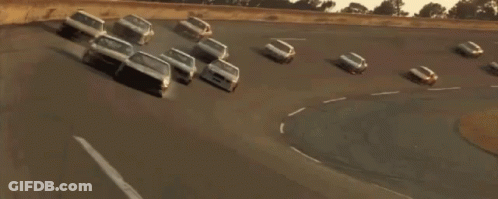 Race Car Driving Down Street With Other Cars GIF