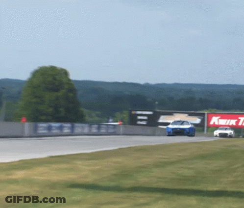 Race Car Going Down Track With Kwik Tire Sign GIF
