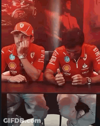 Racing Drivers Sitting With Hands On Faces GIF