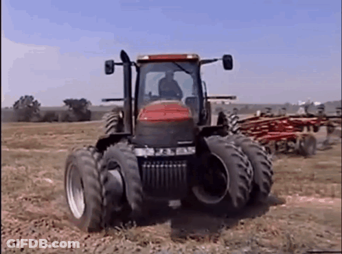 Red And Black Tractor Driving Across Field GIF