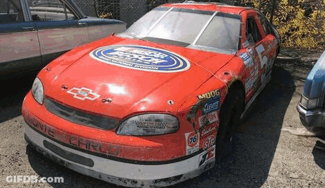 Red And White Race Car Parked Next To Blue Car GIF