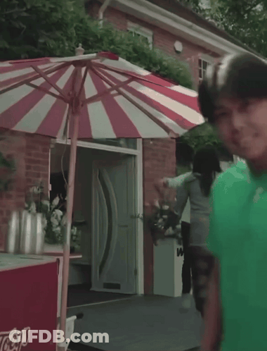 Red And White Striped Umbrella In Front Of Ice Cream Cart That Says Lays GIF