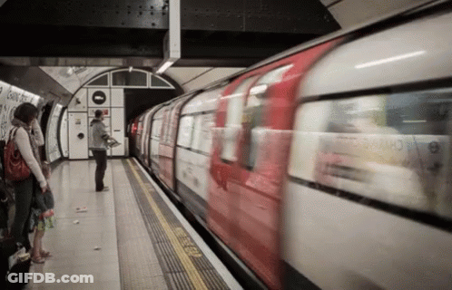 Red And White Train Pulling Into Station With People On Platform GIF