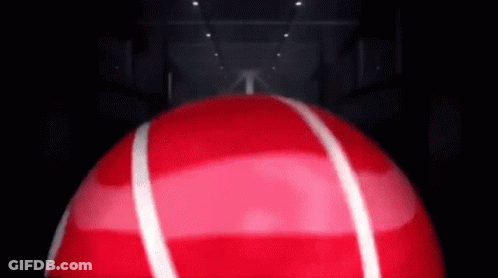Red Ball With White Stripes Spinning In Dark Room GIF