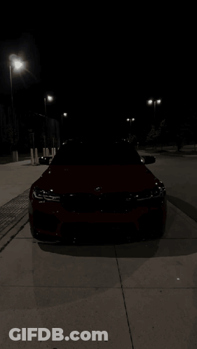 Red BMW Parked On Sidewalk At Night GIF