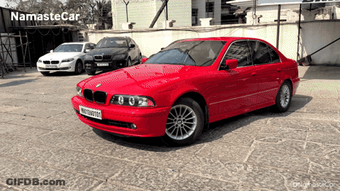 Red BMW Parked With Other Cars Saying Namaste Car GIF