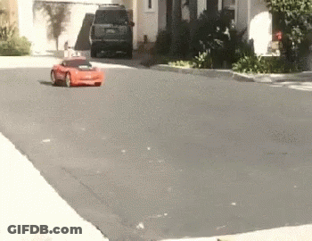 Red Car Driving Down Street Next To House GIF
