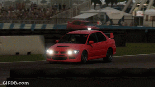Red Car Driving On Race Track With Headlights On GIF