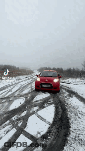 Red Car Driving On Snow Covered Road GIF