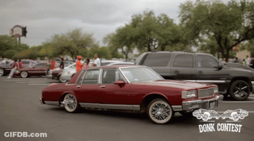 Red Car Parked In Front Of Donk Contest Sign GIF