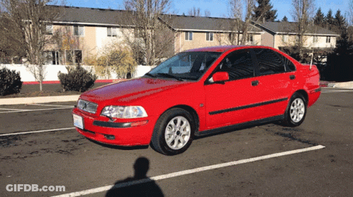 Red Car Parked Outside Apartment Building GIF