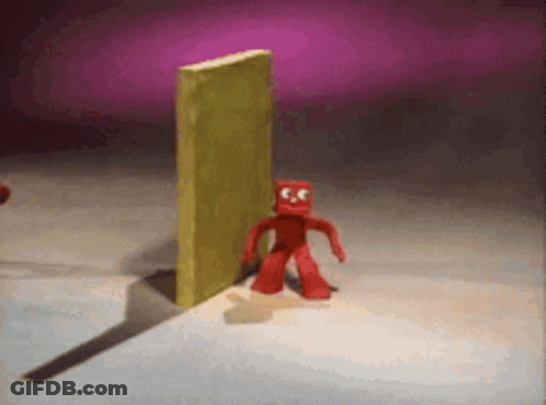 Red Cartoon Character In Front Of Yellow Wall GIF