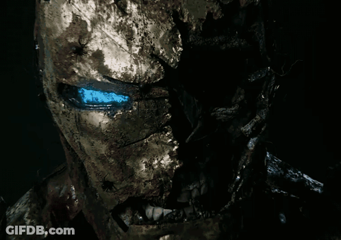 Red Coat Man Looking At Camera In Dark Room GIF
