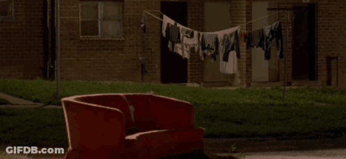 Red Couch By Brick Building With Clothes Line GIF