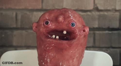 Red Face Statue With Blue Eyes And Teeth GIF