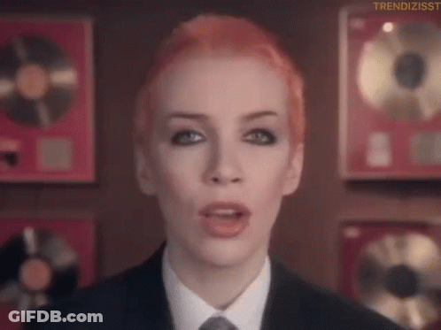 Red Hair Woman In Suit And Tie Before Plaques GIF