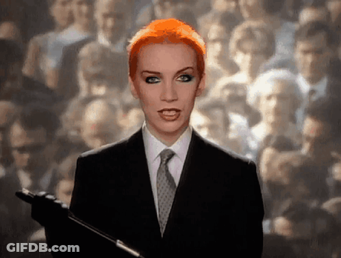 Red Hair Woman In Suit Holding Microphone GIF